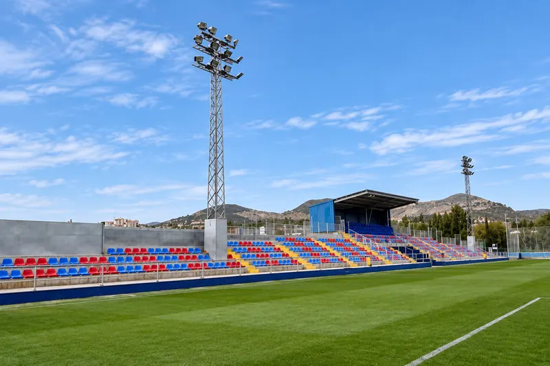 Stand with blue and claret seats beside a natural grass pitch