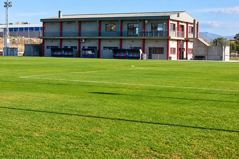 Edificio de la Ciudad Deportiva Levante UD en Buñol junto a un campo de césped