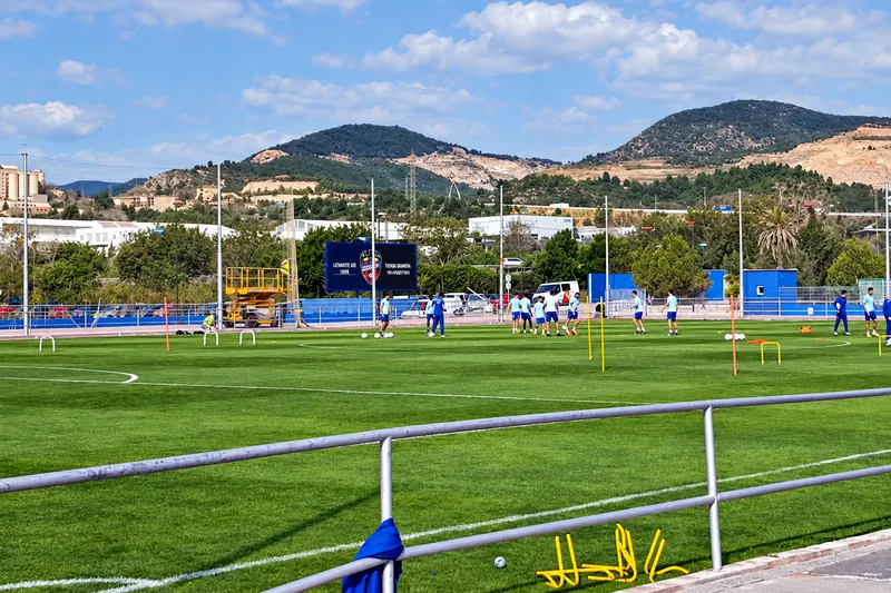 Players training on the reserve team pitch, with the Buñol mountains behind