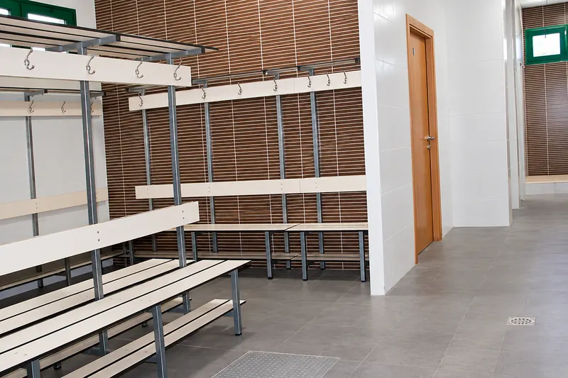 Changing room with wooden benches and coat hooks