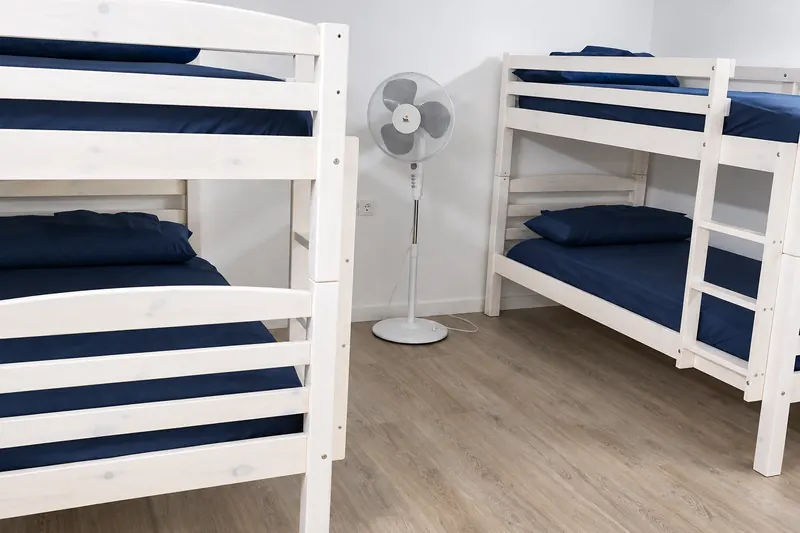 Bedroom with white wooden bunk beds and navy bedding