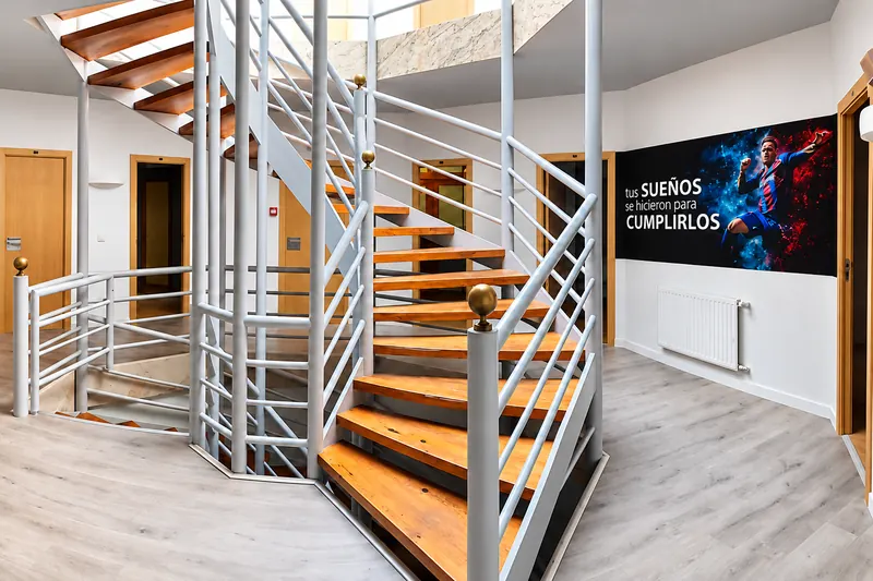 Spiral staircase up to the bedrooms, next to a sign with the motto “Tus sueños se hicieron para cumplirlos” (your dreams were made to come true)